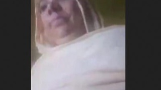 A mature Pakistani woman displays her assets to an older man