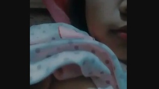 A young woman's breasts are fondled during a sexual encounter