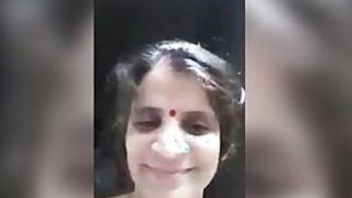 Mature lady in an outfit shows selfies on camera