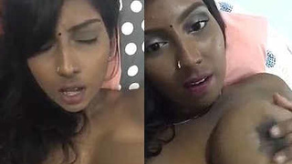 Sultry woman displays her breasts and vagina while pleasuring herself